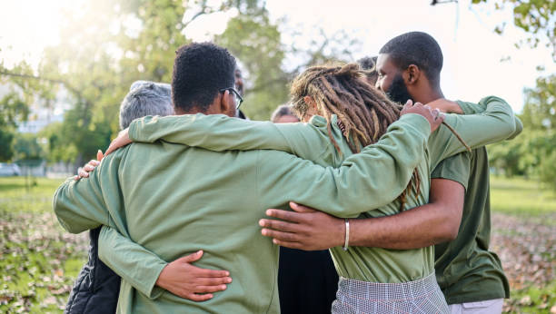 Group hug, support and people in park for eco friendly, sustainable or community service project, teamwork or love. Together, circle and diversity, inclusion friend in forest or nature for earth day