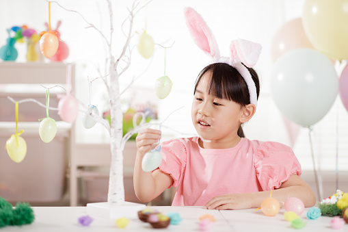 medium shot of young girl was making Easter craft and decorations at home