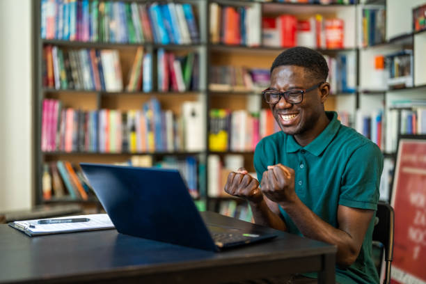 istock Happy african-american student celebrating win on laptop 1478316339
