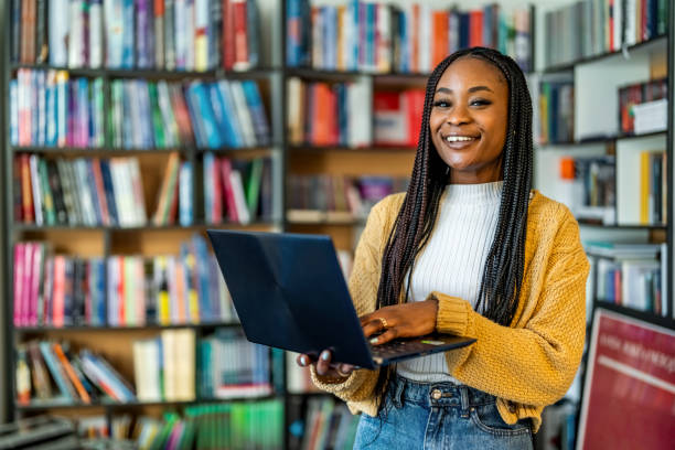 istock Cheerful young woman holding laptop computer 1478316465