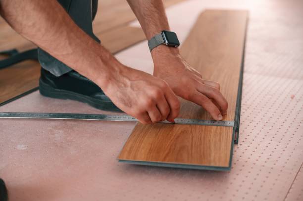 istock Close up view. Man is installing new laminated wooden floor 1478317023