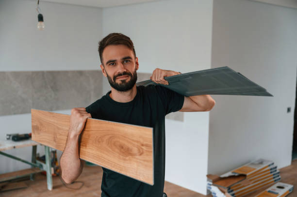 istock Holding the planks. Man is installing new laminated wooden floor 1478317559