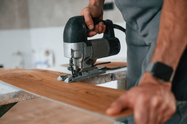 istock Using the electric machine tool to cut the plank. Man is installing new laminated wooden floor 1478317668