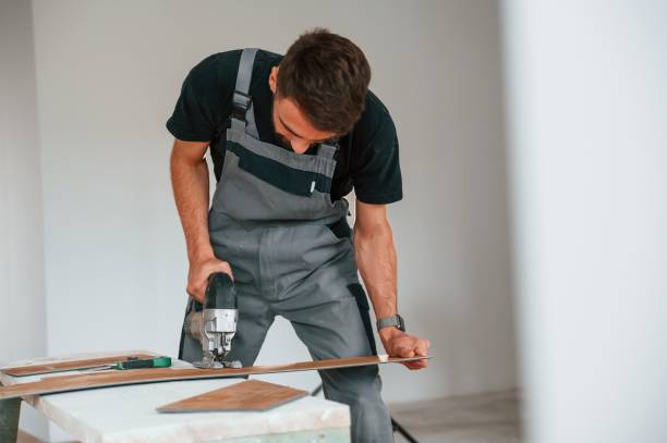 istock Using the electric machine tool to cut the plank. Man is installing new laminated wooden floor 1478317676