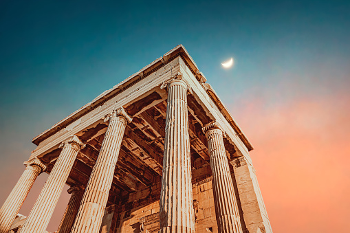 Beautiful ancient temple. High column ruins over colorful sky background with a moon on a side. Scenics destination. Parthenon. Athens. Greece. Europe