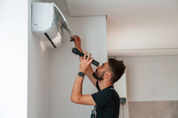 istock Using screwdriver and flashlight. Man repairs an air conditioner indoors at home 1478318635