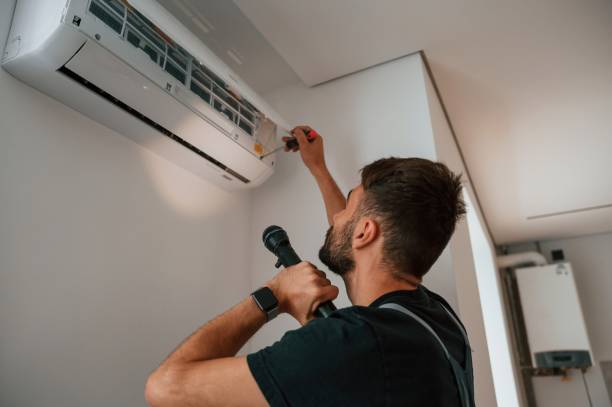 istock Using screwdriver and flashlight. Man repairs an air conditioner indoors at home 1478318644