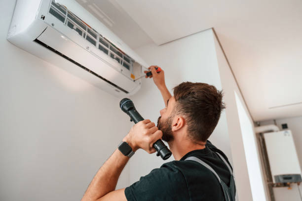 istock Using screwdriver and flashlight. Man repairs an air conditioner indoors at home 1478318655