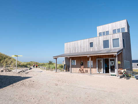 MARKER WADDEN, NETHERLANDS - OCT 8, 2021: People walking on footpath and sustainable wooden visitor centre on Marker Wadden island
