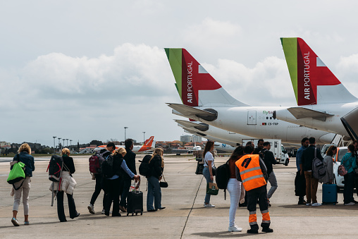 Lisbon, Portugal - March 30, 2023: Passengers boarding an Air Portugal airplane at tarmac in Lisbon, Portugal