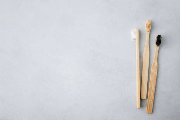 istock Bamboo toothbrushes. Eco friendly bamboo toothbrushes on gray stone background, top view with copy space. 1478324434