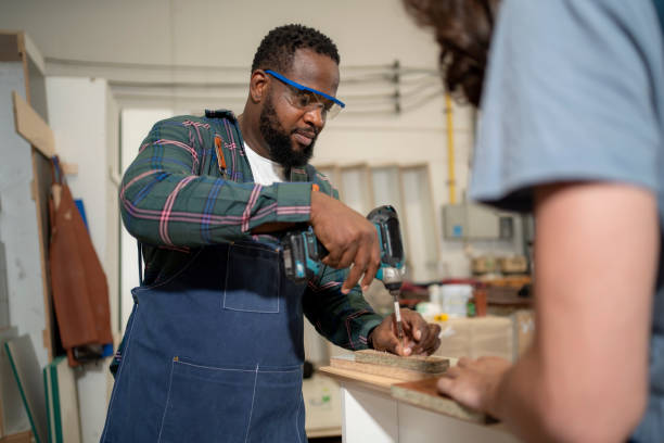 istock Carpenter drills a hole with an electrical drill 1478325261