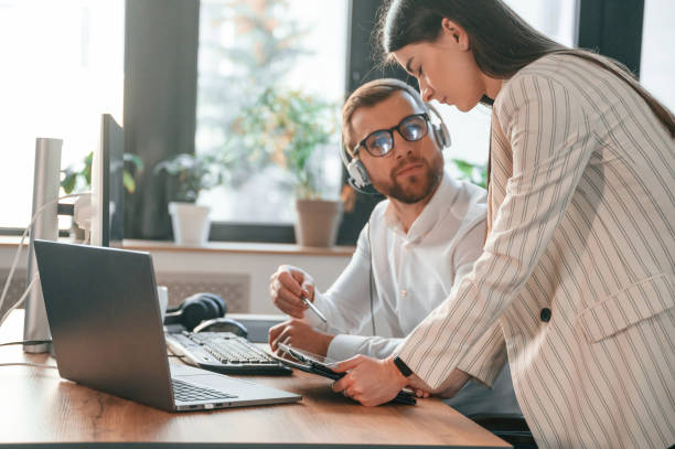 istock Showing information on tablet. Two employees are working together in the modern office 1478327902