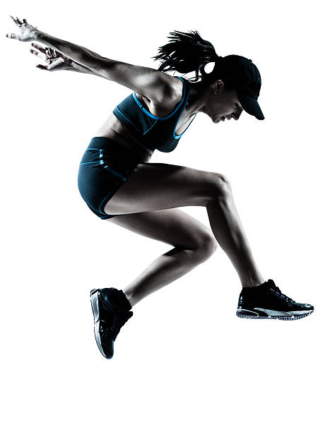 silueta de mujer atleta de salto landing - jumping women running vitality fotografías e imágenes de stock