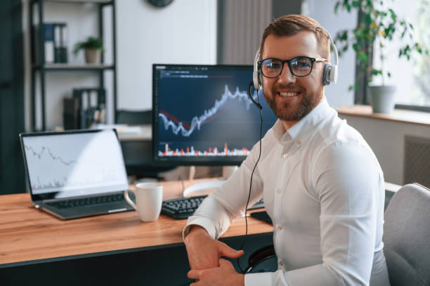 istock Stock exchange graphs on the screen. Man in formal clothes is working in the modern office. Using computer 1478328072