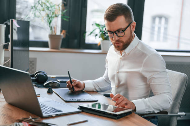 istock Using tablet. Man in formal clothes is working in the modern office 1478328142