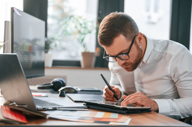 istock Using tablet. Man in formal clothes is working in the modern office 1478328158