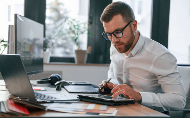 istock Using tablet. Man in formal clothes is working in the modern office 1478328196