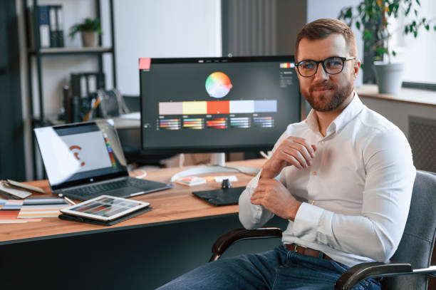 istock Graphic designer is sitting. Man in formal clothes is working in the modern office. Using computer 1478328222