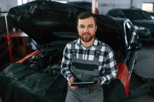 istock With tablet in hands. Man in uniform is working in the auto salon 1478340167