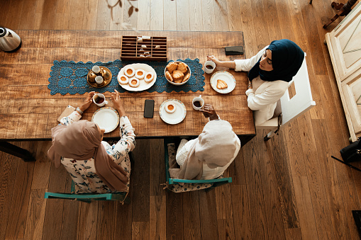 Three friends having breakfast together at home