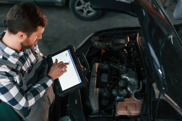 istock With tablet in hands. Man in uniform is working in the auto salon 1478340728