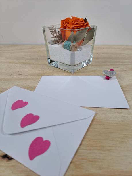 白い紙のカードと安定したバラの花を持つ花柄のグリーティングカード ストックフォト