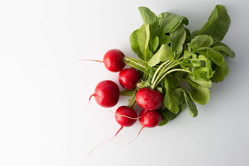 bunch of red radishes on white background. top view