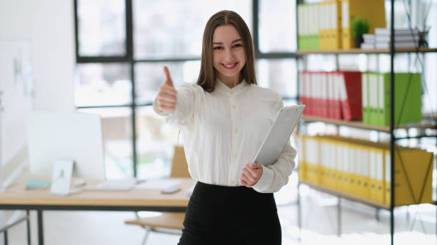 istock Businesswoman showing thumbs up at work in office 1478349132