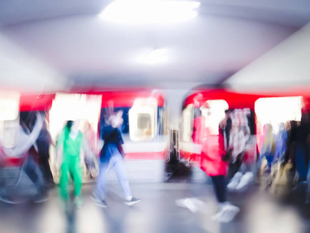 istock Lens blur image of a subway with moving human silhouettes and a train. Motion blur image of people. 1478349896
