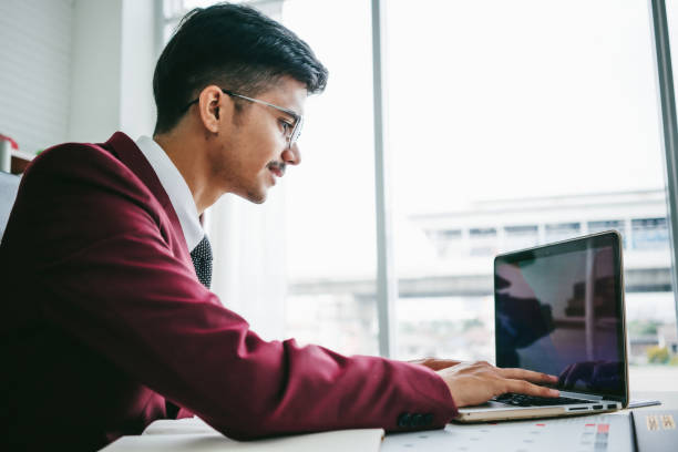 Young businessman typing on laptop keyboard
