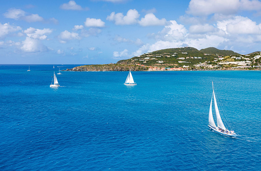 Sailboats on the ocean next to a beautiful island