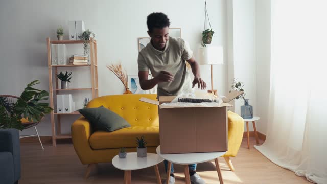 Cheerful black man unboxing some stuff