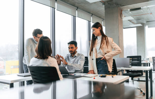 istock By the table. Four people are working in the office together 1478356539