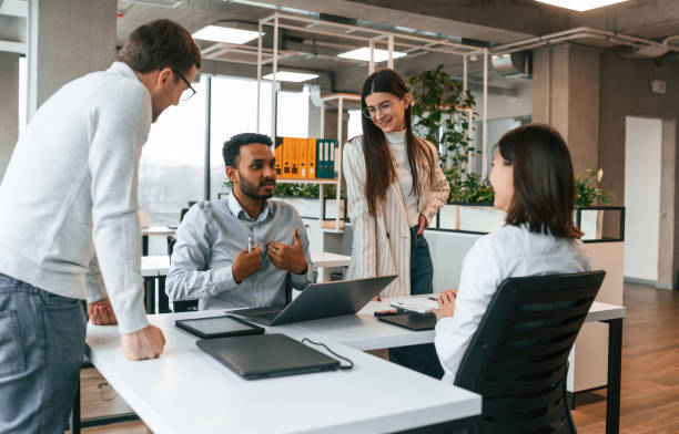 istock By the table. Four people are working in the office together 1478356567