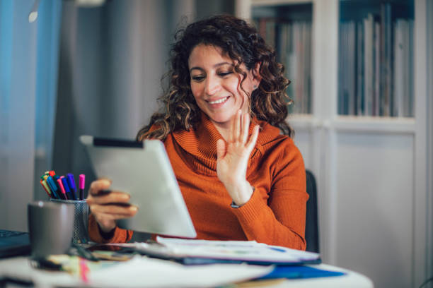 istock Business woman working on digital tablet at home while video call conference call with business partner. 1478358742