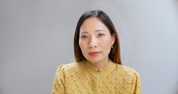 Portrait of businesswoman in front of grey background.