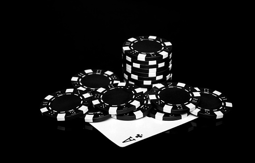 Chips and ace cross on the black table in the casino. Fortune or success in the game of poker.