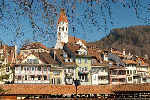 Thun, Switzerland, February 13, 2023 Cityscape with the tower of the historic old church on a hill in the background