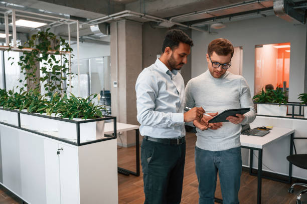 istock Information in the tablet. Two men are working in the modern office together 1478363310