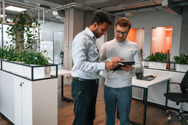istock Information in the tablet. Two men are working in the modern office together 1478363345