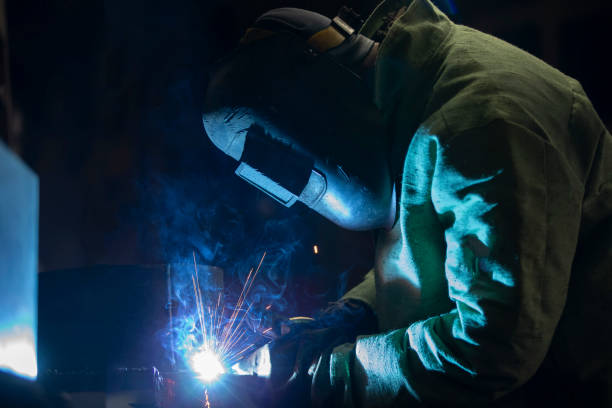istock A worker in a welding suit Welding work with flying sparks. 1478365860