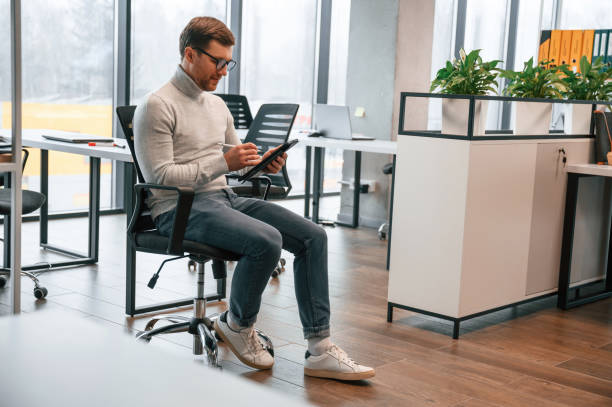 istock Office worker is sitting on the chair in the and using tablet 1478366806