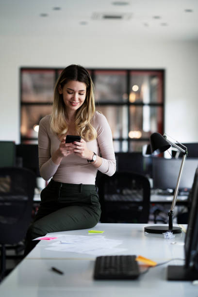 istock Young beautiful woman using the phone in office. 1478367844