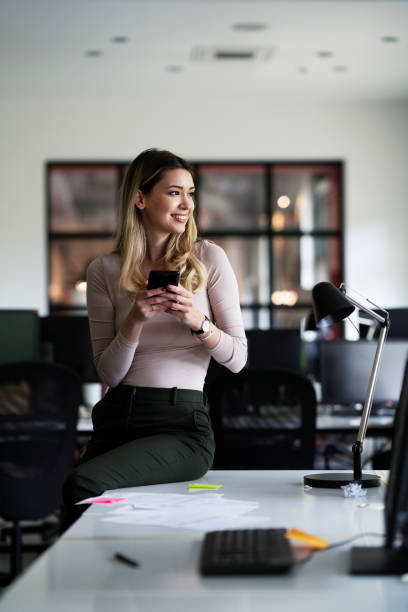 istock Young beautiful woman using the phone in office. 1478367879