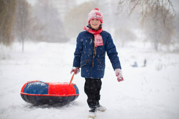 istock A boy pulls a tubing sled across the snow on a winter day. 1478367962