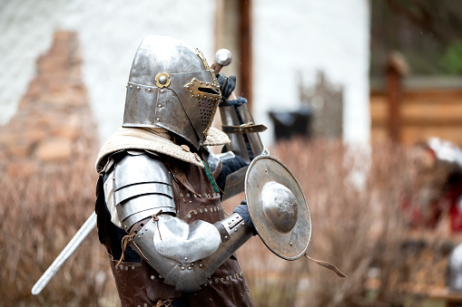 Medieval knight in full armor with hard weapon outdoor