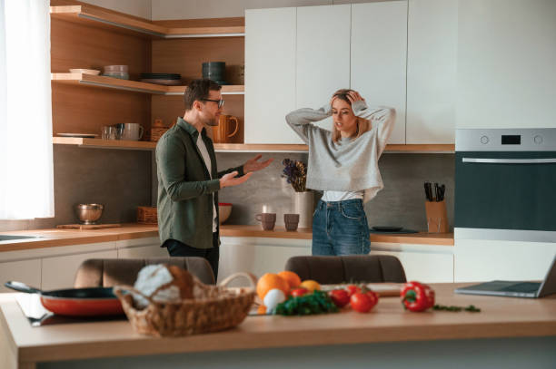 Shouting at each other, quarrel. Young couple is on the kitchen together Shouting at each other, quarrel. Young couple is on the kitchen together. terrible meal stock pictures, royalty-free photos & images