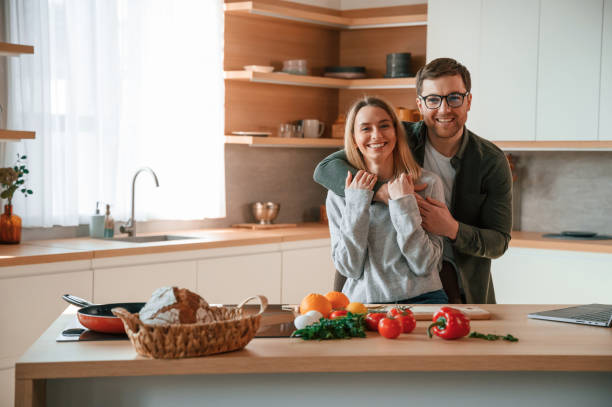 istock Embracing each other. Young couple is on the kitchen together 1478369724