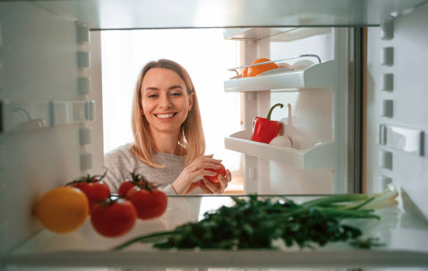 istock Taking the vegetables from fridge. Beautiful young woman is on the kitchen 1478369802